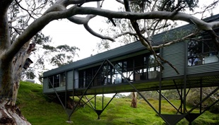 When Max Pritchard's clients approached him to design a small house overlooking a picturesque creek on their farm, they never imagined that he would perch them above the waterway,but they've come to love his lofty solution.
